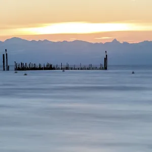Soft reflections on the lake at sunrise with mountain panorama