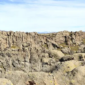 The solid Peruvian mountain wall consists of many porous vertical aged red granite stones The solid Peruvian mountain wall consists of many porous vertical aged red granite stones