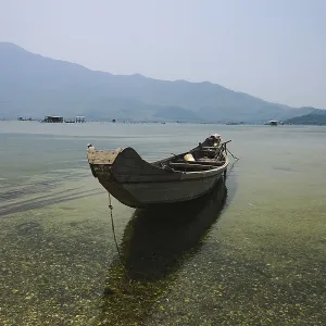 A solitary boat on still water with a clear mountain view