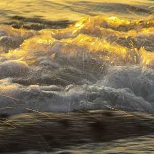 Spray, waves on the beach, sunset
