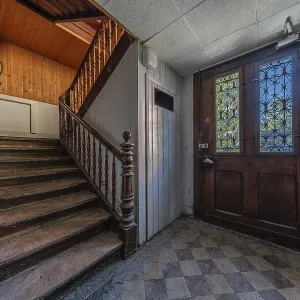 Staircase with main entrance door of a multi-storey residential building built in 1903 in front of demolition work