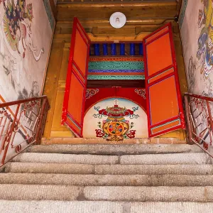 Stairs leading to a painted door of a Tibetan prayer hall at Kumbum Champa Ling Monastery near Xining