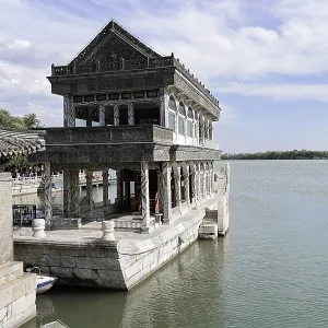 Stone building on water with traditional architecture under blue sky Stone building on water with traditional architecture under blue sky