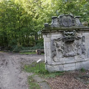 Stone monument at the edge of a forest along a path Stone monument at the edge of a forest along a path
