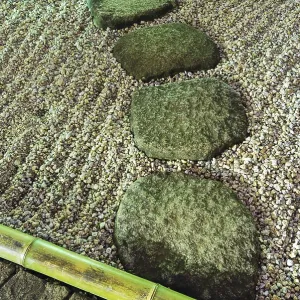 Stone way elements in zen garden under vivid night illumination with sand waves and bamboo pole border