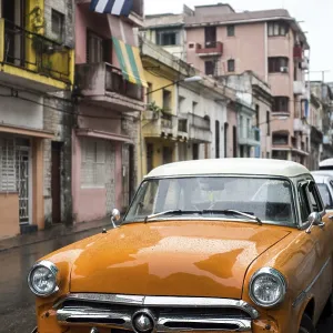 Street scene with old car on rainy day in Havana