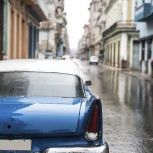 Street scene with old car on rainy day in Havana
