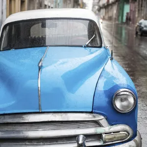 Street scene with old car on rainy day in Havana