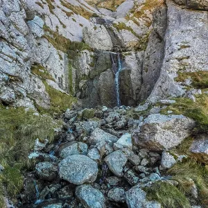 Stunning waterfall cascades down rugged rocks in mount txindoki Stunning waterfall cascades down rugged rocks in mount txindoki