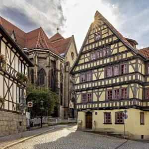 Sun-drenched street with half-timbered house and church Sun-drenched street with half-timbered house and church