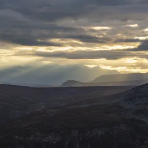 Sun rays fall through clouds in mountain landscape Sun rays fall through clouds in mountain landscape