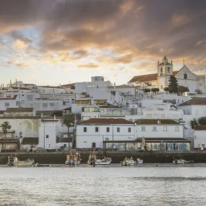 Sunrise on the Atlantic, skyline of a fishing village behind a harbour Sunrise on the Atlantic, skyline of a fishing village behind a harbour