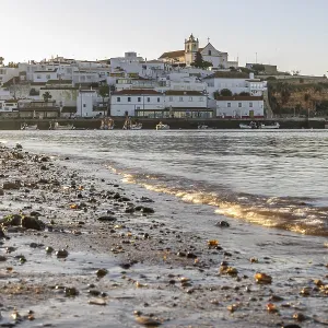 Sunrise on the Atlantic, skyline of a fishing village behind a harbour Sunrise on the Atlantic, skyline of a fishing village behind a harbour