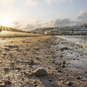 Sunrise on the Atlantic, skyline of a fishing village behind a harbour Sunrise on the Atlantic, skyline of a fishing village behind a harbour