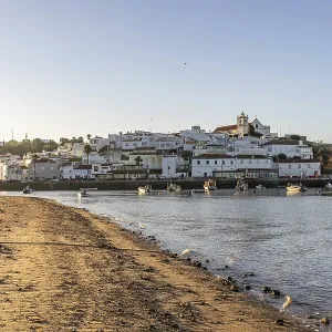 Sunrise on the Atlantic, skyline of a fishing village behind a harbour Sunrise on the Atlantic, skyline of a fishing village behind a harbour