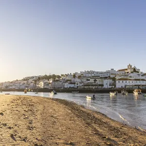 Sunrise on the Atlantic, skyline of a fishing village behind a harbour Sunrise on the Atlantic, skyline of a fishing village behind a harbour