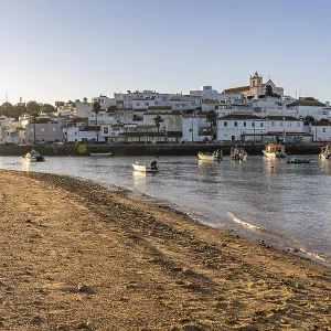 Sunrise on the Atlantic, skyline of a fishing village behind a harbour Sunrise on the Atlantic, skyline of a fishing village behind a harbour
