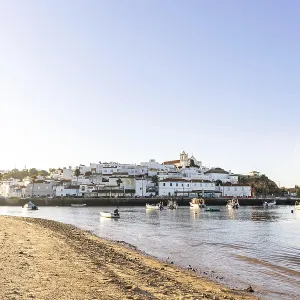 Sunrise on the Atlantic, skyline of a fishing village behind a harbour Sunrise on the Atlantic, skyline of a fishing village behind a harbour