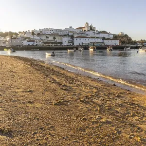 Sunrise on the Atlantic, skyline of a fishing village behind a harbour Sunrise on the Atlantic, skyline of a fishing village behind a harbour