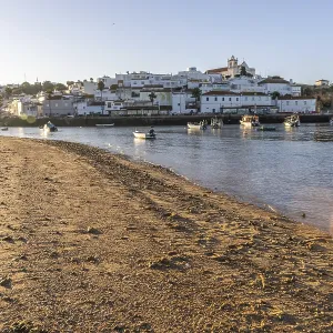 Sunrise on the Atlantic, skyline of a fishing village behind a harbour Sunrise on the Atlantic, skyline of a fishing village behind a harbour