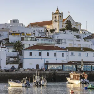 Sunrise on the Atlantic, skyline of a fishing village behind a harbour Sunrise on the Atlantic, skyline of a fishing village behind a harbour