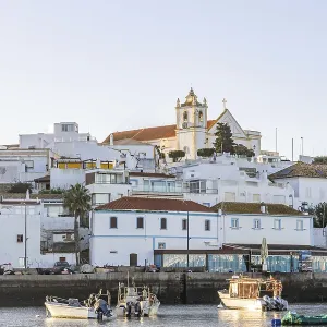 Sunrise on the Atlantic, skyline of a fishing village behind a harbour Sunrise on the Atlantic, skyline of a fishing village behind a harbour