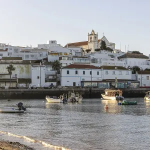 Sunrise on the Atlantic, skyline of a fishing village behind a harbour Sunrise on the Atlantic, skyline of a fishing village behind a harbour