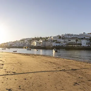 Sunrise on the Atlantic, skyline of a fishing village behind a harbour Sunrise on the Atlantic, skyline of a fishing village behind a harbour
