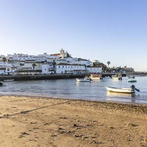 Sunrise on the Atlantic, skyline of a fishing village behind a harbour Sunrise on the Atlantic, skyline of a fishing village behind a harbour