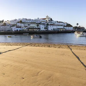 Sunrise on the Atlantic, skyline of a fishing village behind a harbour Sunrise on the Atlantic, skyline of a fishing village behind a harbour