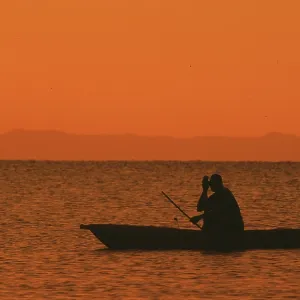 Sunrise over Lake Malawi, man in dugout Sunrise over Lake Malawi, man in dugout