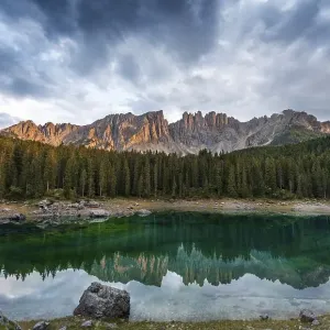 Sunset, dramatic clouds, Latemar group reflected in the Karersee