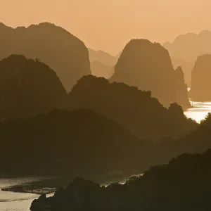 Sunset, limestone cliffs with vegetation in Halong Bay