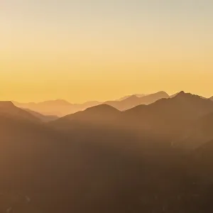 Sunset behind mountain silhouette Sunset behind mountain silhouette
