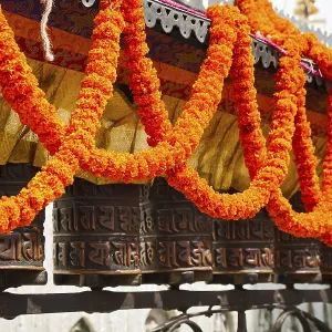Swayambhunath. Prayer wheel, decorated with garlands of flowers