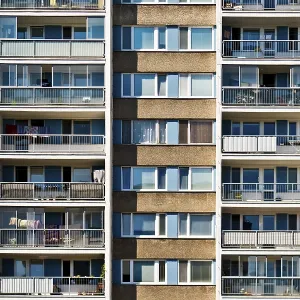 A symmetrical high-rise apartment building with balconies