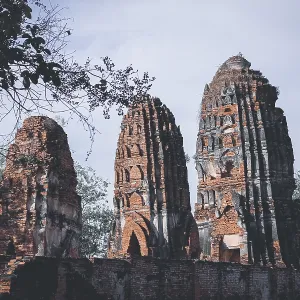 Tall brick ruins and towers reaching towards the sky amidst surrounding trees