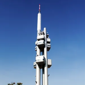 Tall tower with multiple antennas reaching into a clear blue sky