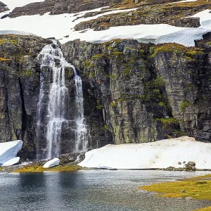Tall waterfall falls into the lake Tall waterfall falls into the lake