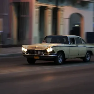 Taxi, American vintage car driving on the Malecon at twilight