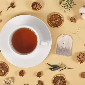 Tea cup surrounded by seasonal forest decoration on beige background Tea cup surrounded by seasonal forest decoration on beige background