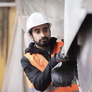Technician with beard and helmet works in a workshop Technician with beard and helmet works in a workshop