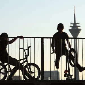 Teenagers with BMX bikes at a halfpipe on the Rhine Teenagers with BMX bikes at a halfpipe on the Rhine