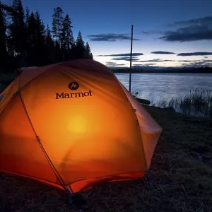 Tent illuminated from the inside at dusk on a lakeside Tent illuminated from the inside at dusk on a lakeside