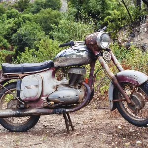 The thrown abandoned old rusty brown vintage motorcycle