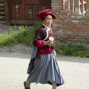 Tibetan Buddhism, ethnology, woman of the Mosu ethnicity dressed in traditional costume swinging a prayer wheel Tibetan Buddhism, ethnology, woman of the Mosu ethnicity dressed in traditional costume swinging a prayer wheel