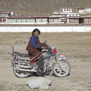 Tibetan man riding motorbike in front of monastery between Sershu Dzong and Sershu