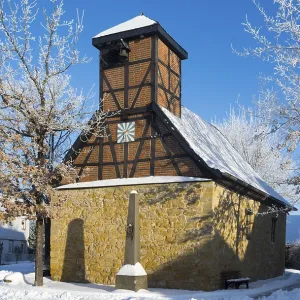 Timbered church in snowcoat with clear blue sky in background