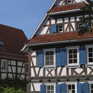 Timbered house with blue shutters under blue sky