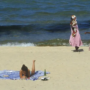 Tourist in bikini and traditionally dressed local woman at Kande Beach on Lake Malawi Tourist in bikini and traditionally dressed local woman at Kande Beach on Lake Malawi